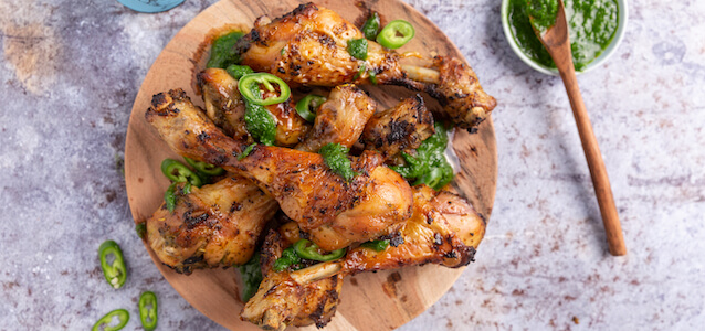 Plate of chicken drumsticks cooked in the air fryer with a spicy marinade