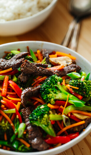 Beef stir-fry with bowl of rice