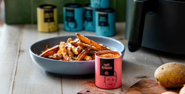 A plate of air fryer chips, Chips Seasoning and other spice blends from Just Spices, and an air fryer