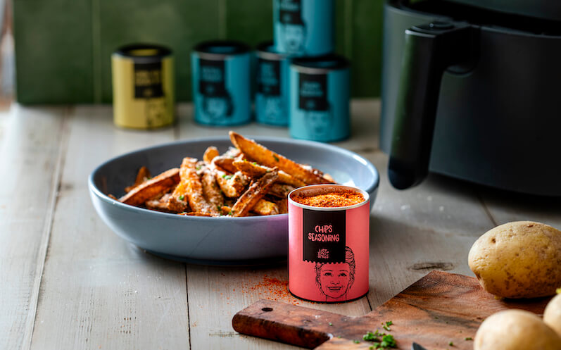 Air fryer fries with Chips Seasoning from Just Spices with an air fryer in the background