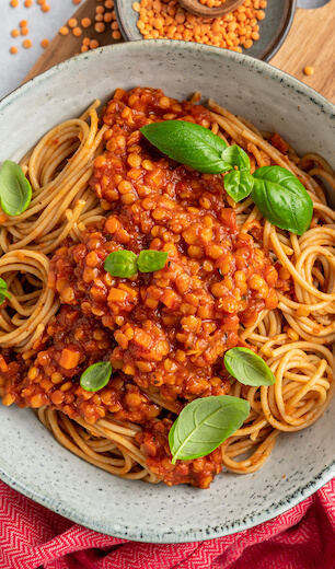 Vegan lentil spaghetti bolognese from Just Spices garnished with basil