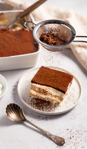 Vegan tiramisu from Just Spices with seived cocoa powder and silver spoon